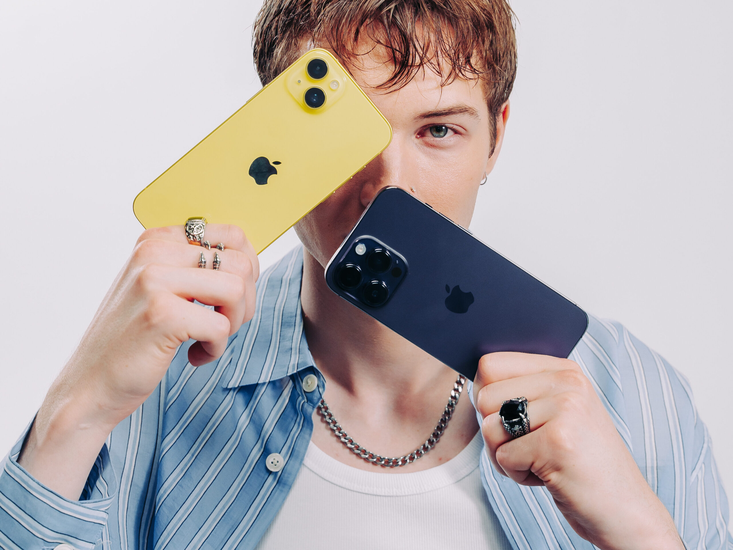 Kille håller upp två iPhones Kille håller upp två iPhones vilket symboliserar jämförelsen