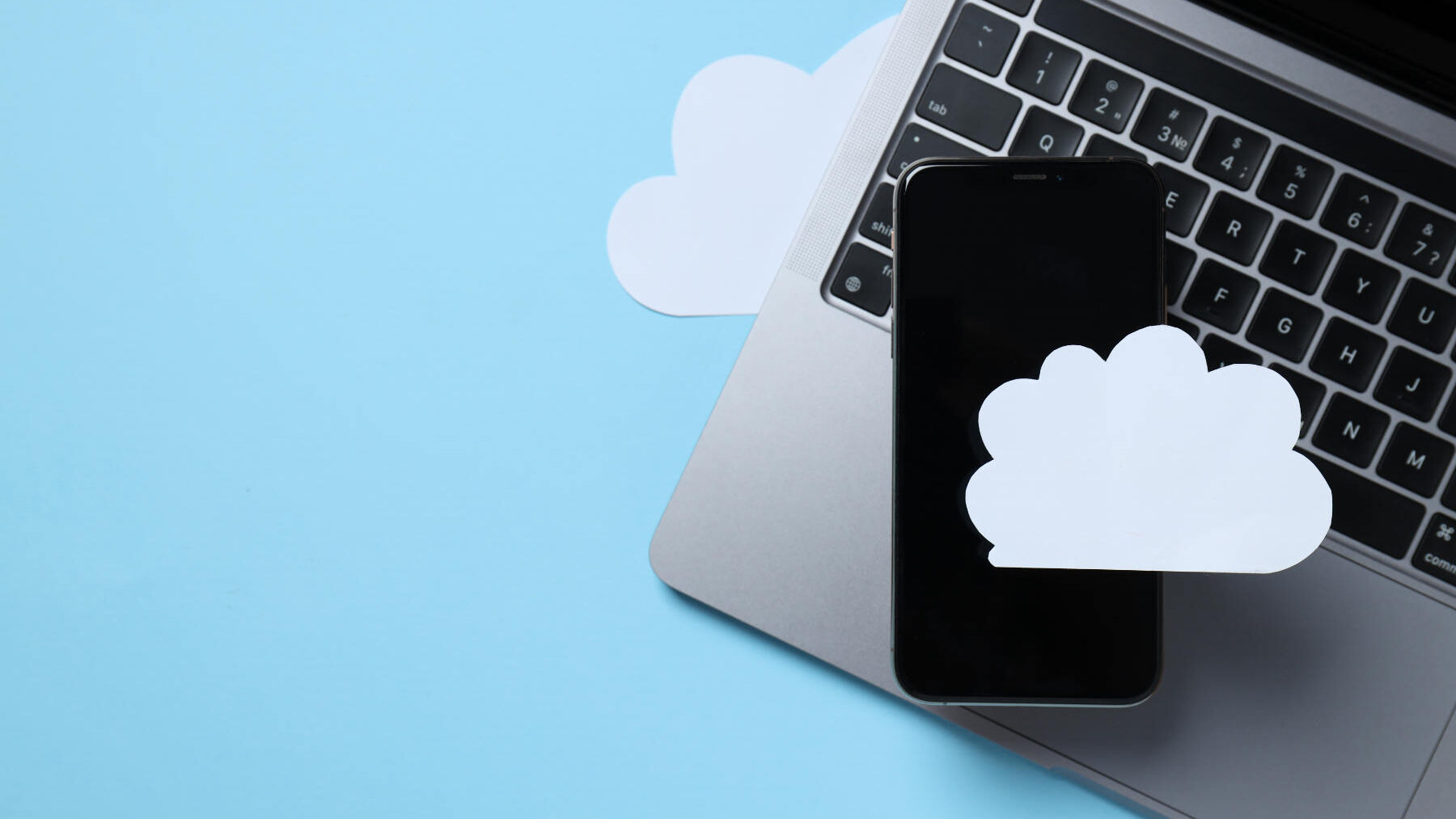 Black smartphone with a paper white cloud on a blue background