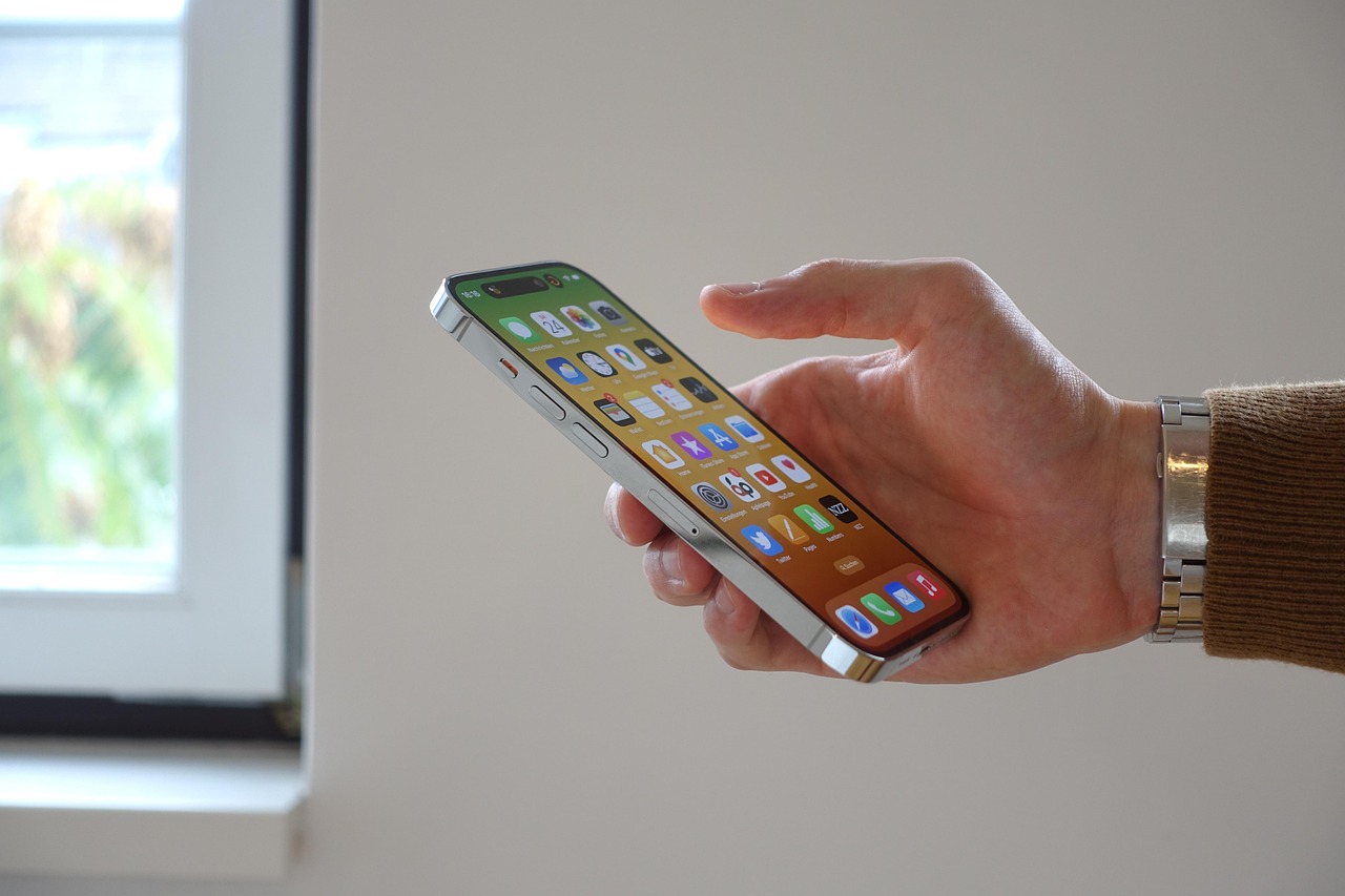 iPhone i killes hand Kille scrollar på sin iPhone för att optimera sitt iPhone-batteri